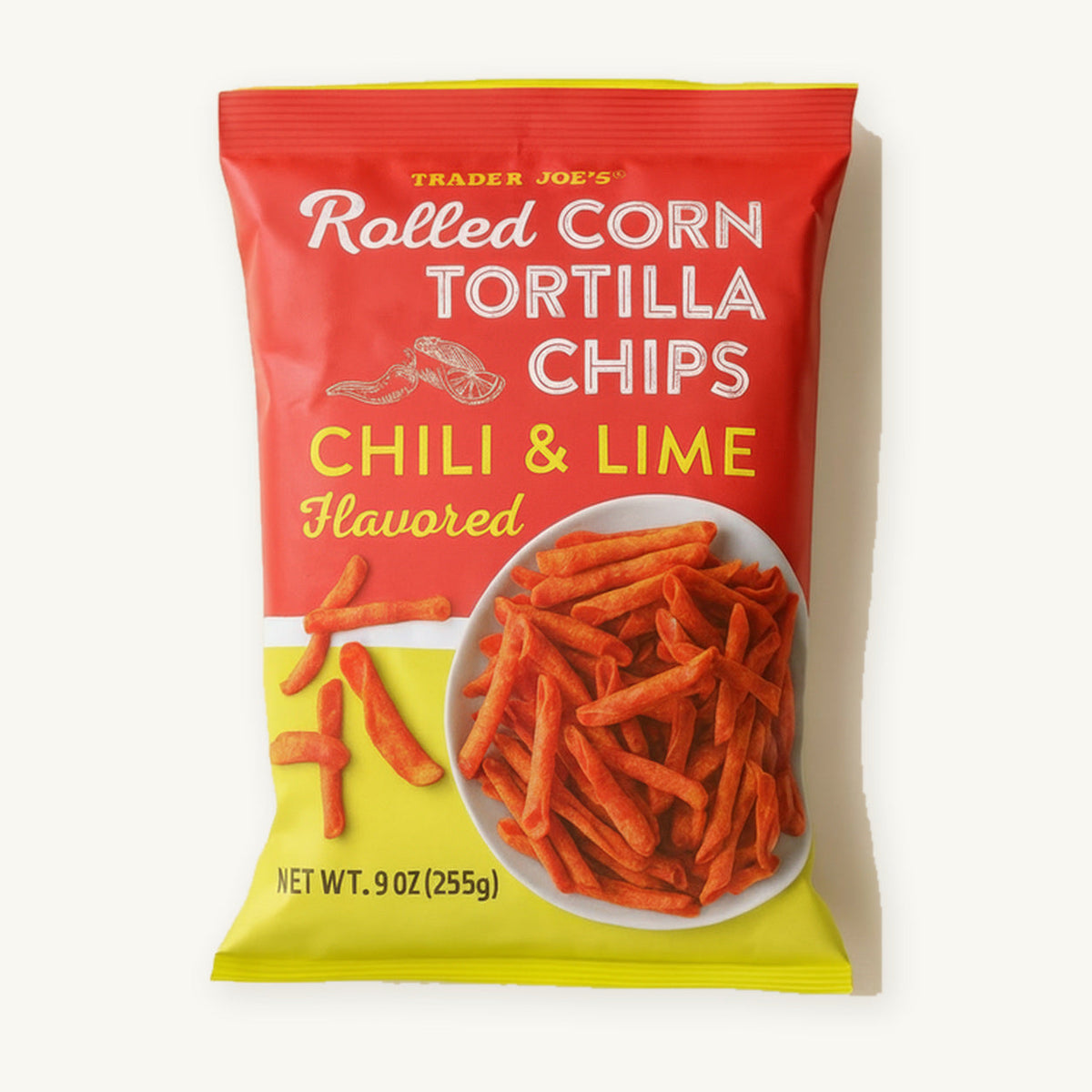 Trader Joe's Chili & Lime Flavored Rolled Corn Tortilla Chips, 9 oz. Red and yellow bag on a warm ivory background.